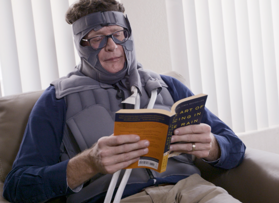 Head and Neck Lymphedema Patient Using Flexitouch Plus while reading a book